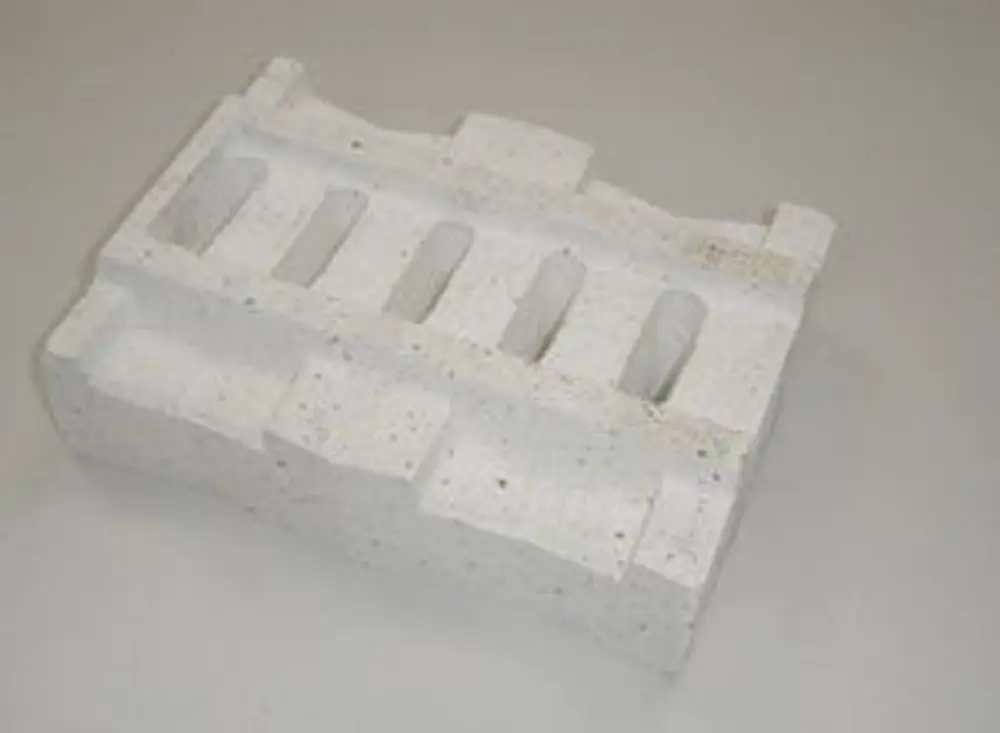 Weiße Vorlage aus speziellem Material mit mehreren Vertiefungen, möglicherweise zur Verwendung in Heizsystemen, hergestellt von Remeha.